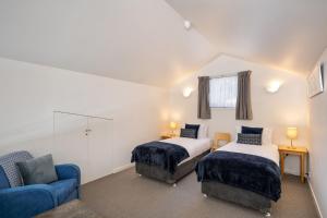 sypialnia z 2 łóżkami i niebieską kanapą w obiekcie Squatters Run Unit 11 w mieście Thredbo