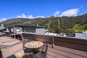 a patio with a table and chairs on a balcony at Squatters Run Unit 11 in Thredbo