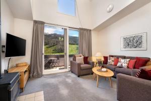a living room with a couch and a tv at Squatters Run Unit 11 in Thredbo