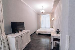 a small room with a television and a bed at Gold Georg Palace Hotel in Chernivtsi