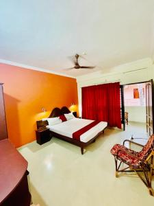 a bedroom with a bed and a red curtain at Moon Valley Cottage in Kovalam