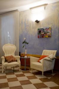 ein Wohnzimmer mit 2 Stühlen und einem Tisch in der Unterkunft Art Hotel Al Fagiano in Padua