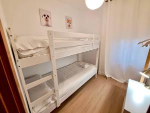 グラナダにあるAcogedor apartamento pleno centro de Granada y PARKINGの小さな部屋の白い二段ベッド1台分です。