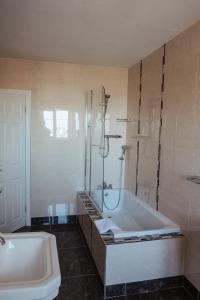 een badkamer met een bad, een douche en een wastafel bij Lehinch Lodge in Lahinch