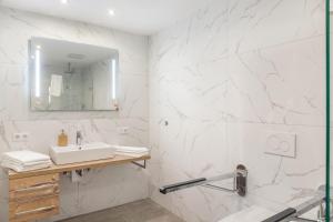 ein weißes Badezimmer mit einem Waschbecken und einem Spiegel in der Unterkunft Ferienwohnung Zugspitze in Ehrwald