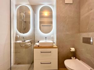 a bathroom with a sink and a mirror at Garnizon by Q4Apartments in Gdańsk