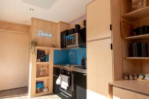 uma cozinha com um lavatório e um fogão em The Reef - Unique Cabin in Millport em Millport