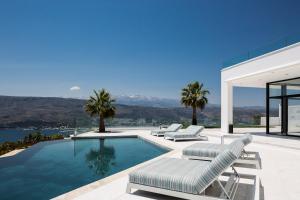 a house with a swimming pool and two lounge chairs at Paul's Mansion in Chania