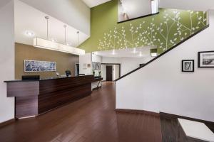 an office lobby with a staircase with green and white walls at Sleep Inn Athens I-65 in Athens