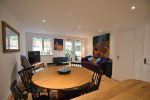 a dining room and living room with a wooden table and chairs at Southbank in Rye