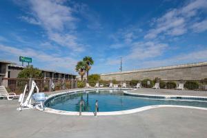 a large swimming pool with chairs and a building at Quality Inn in Rock Hill