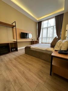 een slaapkamer met een bed, een televisie en een bureau bij Berfinn Hotel Ortaköy in Istanbul