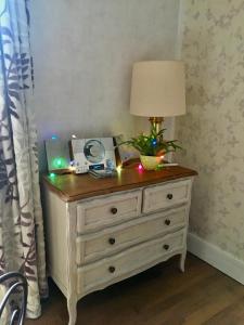 a dresser with a lamp and christmas lights on it at La petite duchesse in Vernon