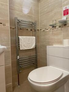 a bathroom with a toilet and a towel rack at The Sandrock in Clacton-on-Sea