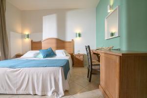 a bedroom with a bed and a desk with a mirror at Elbamar Marina Di Campo in Marina di Campo