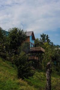 ein Haus auf einem Hügel mit einer Holzterrasse in der Unterkunft Hill Inn in K'eda