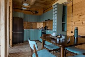 K'eda的住宿－Hill Inn，厨房配有蓝色橱柜和桌椅