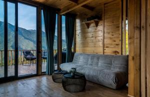 a living room with a couch and large windows at Hill Inn in K'eda