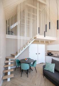 ein Wohnzimmer mit einem Tisch und einer Treppe in der Unterkunft Baltico Stodoła in Mielno