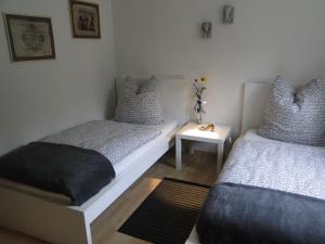 a bedroom with two beds and a table with a night stand at Ferienwohnung Hotte´s Hütte in Ettenheim