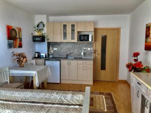 a kitchen with white cabinets and a table and a counter at Apartment 9 in Balchik