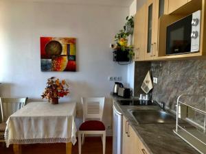 una cocina con mesa, fregadero y una pintura en Apartment 9, en Balchik 13 fotos más