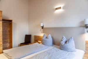 um quarto com 2 camas com almofadas azuis e brancas em Ferienwohnung Grubig em Ehrwald