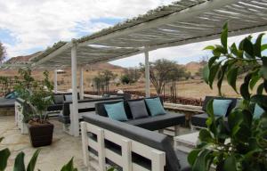 a row of outdoor furniture under a pergola at Elegant Desert Lodge in Sesriem