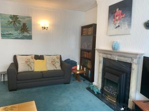a living room with a couch and a fireplace at Tan y Coed in Rhos-on-Sea