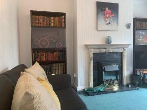 a living room with a couch and a fireplace at Tan y Coed in Rhos-on-Sea