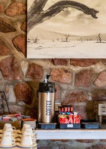 Elegant Desert Lodge في سيسريم: وعاء القهوة على رف في جدار حجري