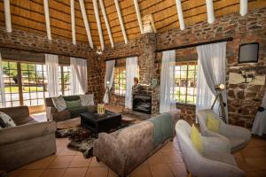 a living room with couches and a brick wall at Elegant Desert Lodge in Sesriem