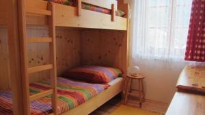 a bedroom with two bunk beds with a stool at Apartments Berghof Familie Steinwender in Pölling