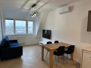 salon ze stołem jadalnym i krzesłami w obiekcie Apartament Metropolis 15 w Toruniu