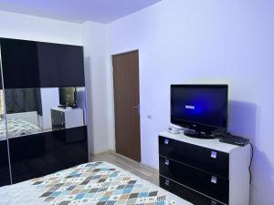 - une chambre avec une télévision à écran plat sur une commode dans l'établissement B&B Iulius, à Cluj-Napoca