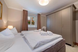 ein Schlafzimmer mit einem großen Bett mit weißer Bettwäsche in der Unterkunft Villa Quisisana in Binz