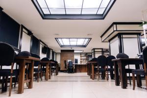 una habitación vacía con sillas, mesas y ventanas en Gold Georg Palace Hotel, en Chernivtsi