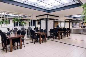 a dining room with tables and chairs in a restaurant at Gold Georg Palace Hotel in Chernivtsi