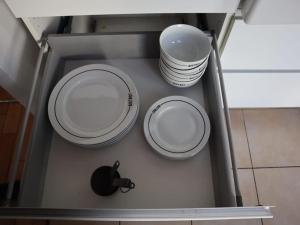 two plates and bowls on a shelf in a drawer at Magnifique appartement à 5 min de Paris et 10 min de l'aéroport d'Orly in Choisy-le-Roi +24 photos