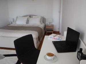 a bedroom with a bed and a laptop on a desk at Magnifique appartement à 5 min de Paris et 10 min de l'aéroport d'Orly in Choisy-le-Roi