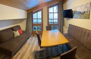 uma sala de estar com um sofá e uma mesa de madeira em Landhaus Rosengartl Krimml em Oberkrimml