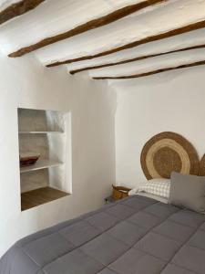 1 dormitorio con 1 cama en una habitación blanca en La casilla de Vicente, en Torres