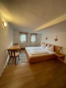a bedroom with a large bed and a table at Müllnerhof in Aich