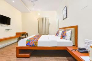 a bedroom with a bed and a desk and a television at FabHotel Royal Icon in Udaipur