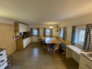 a kitchen and dining room with a table and chairs at Müllnerhof in Aich