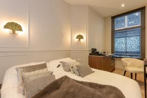 a bedroom with a bed and a desk and a window at Novallure City Centre in The Hague