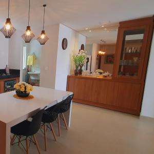 eine Küche mit einem Tisch, Stühlen und einer Theke in der Unterkunft Casa Mutá in Porto Seguro