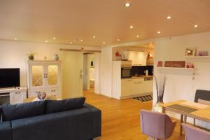 a living room with a couch and a table and a kitchen at Klein's Hochwaldscheune in Pellingen
