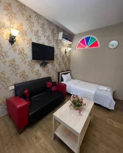 a living room with a couch and a bed at Hotel Sanapiro Tbilisi in Tbilisi City