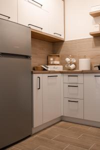 a kitchen with white cabinets and a refrigerator at 16DI in Kraljevo